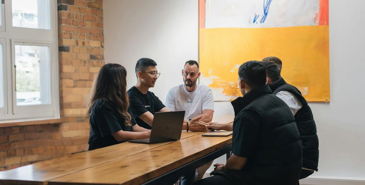 Onboard team in a discussion around a meeting table